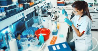 A Mayne Pharma worker in a lab surrounded by vials and bottles.